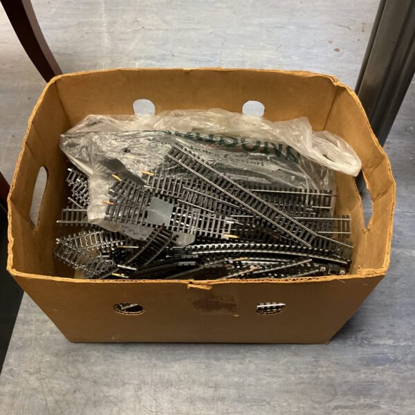 Large bundle of OO gauge railway track pieces in a cardboard box.