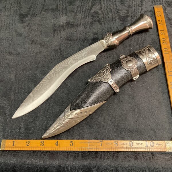 Ornate Oriental Khukuri knife with curved blade and decorated handle.