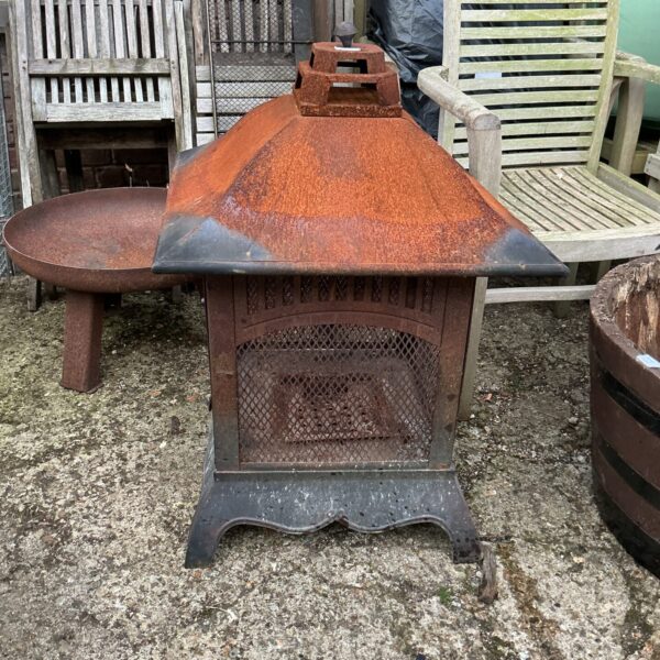 Ornate metal fire basket with intricate detailing, vintage fireplace accessory.