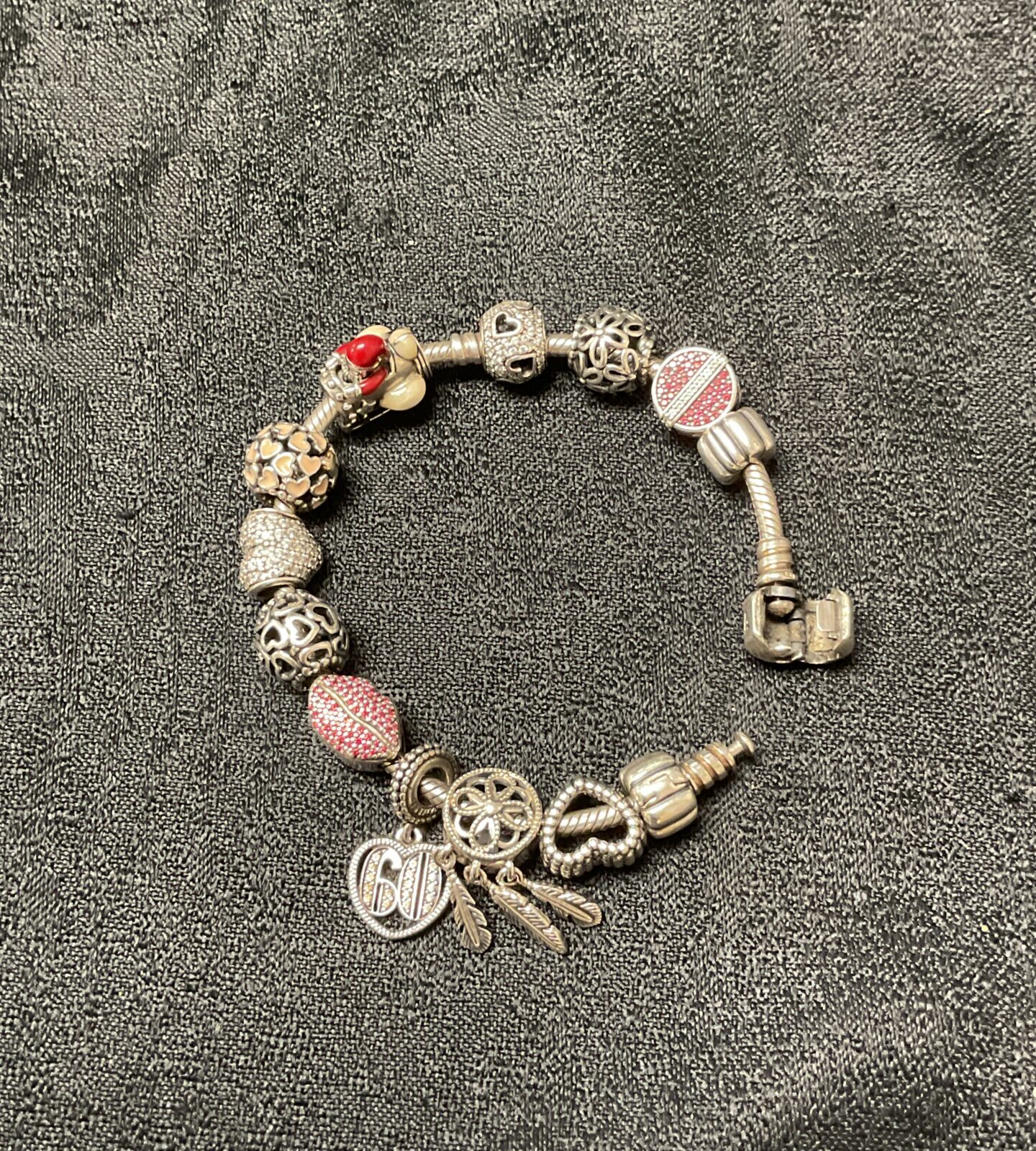 Silver Pandora charm bracelet with twelve detailed charms.