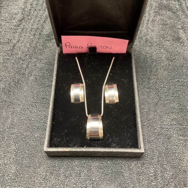 Paula Bolton silver necklace and earring set on display.