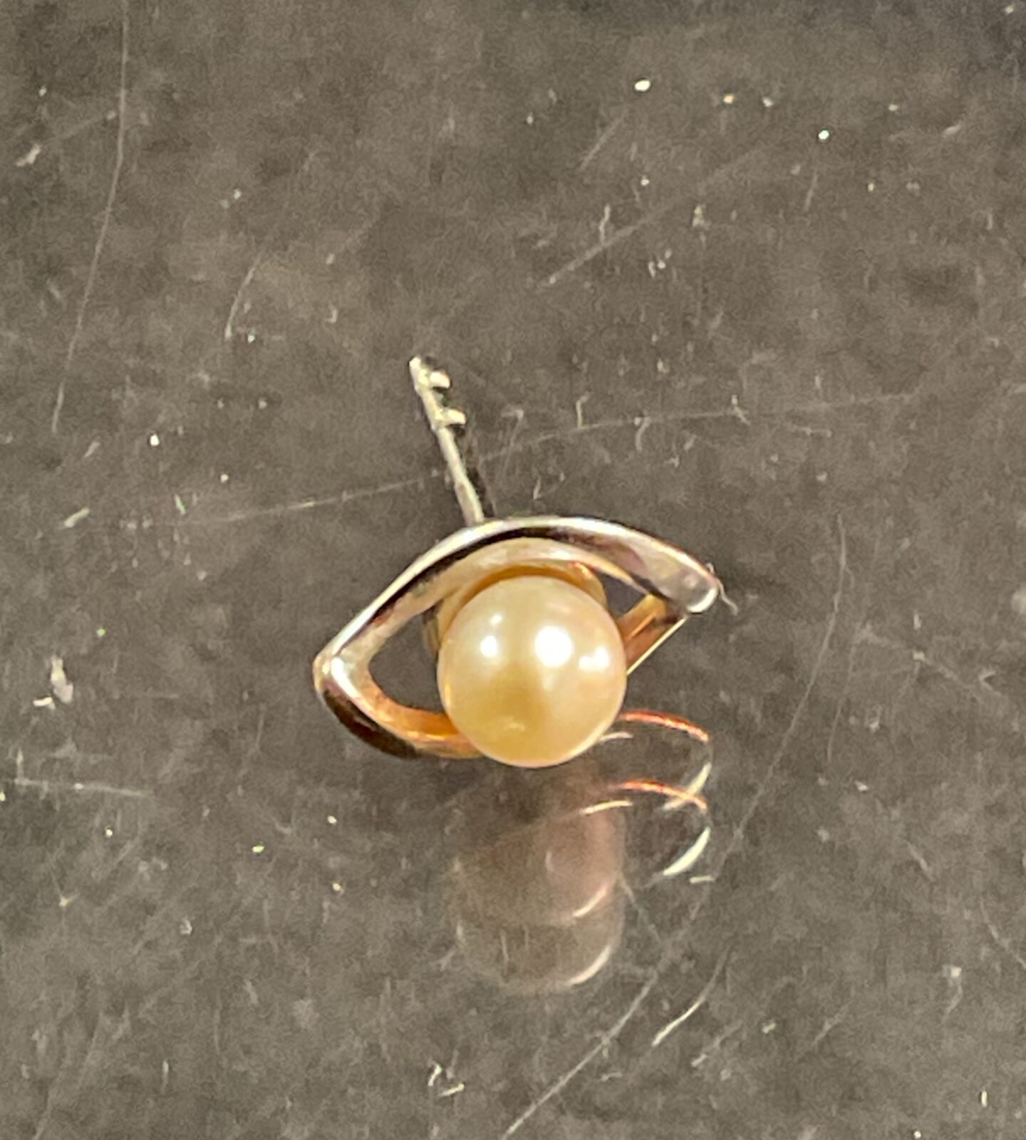 Close-up of a 9 carat gold and pearl stud earring.