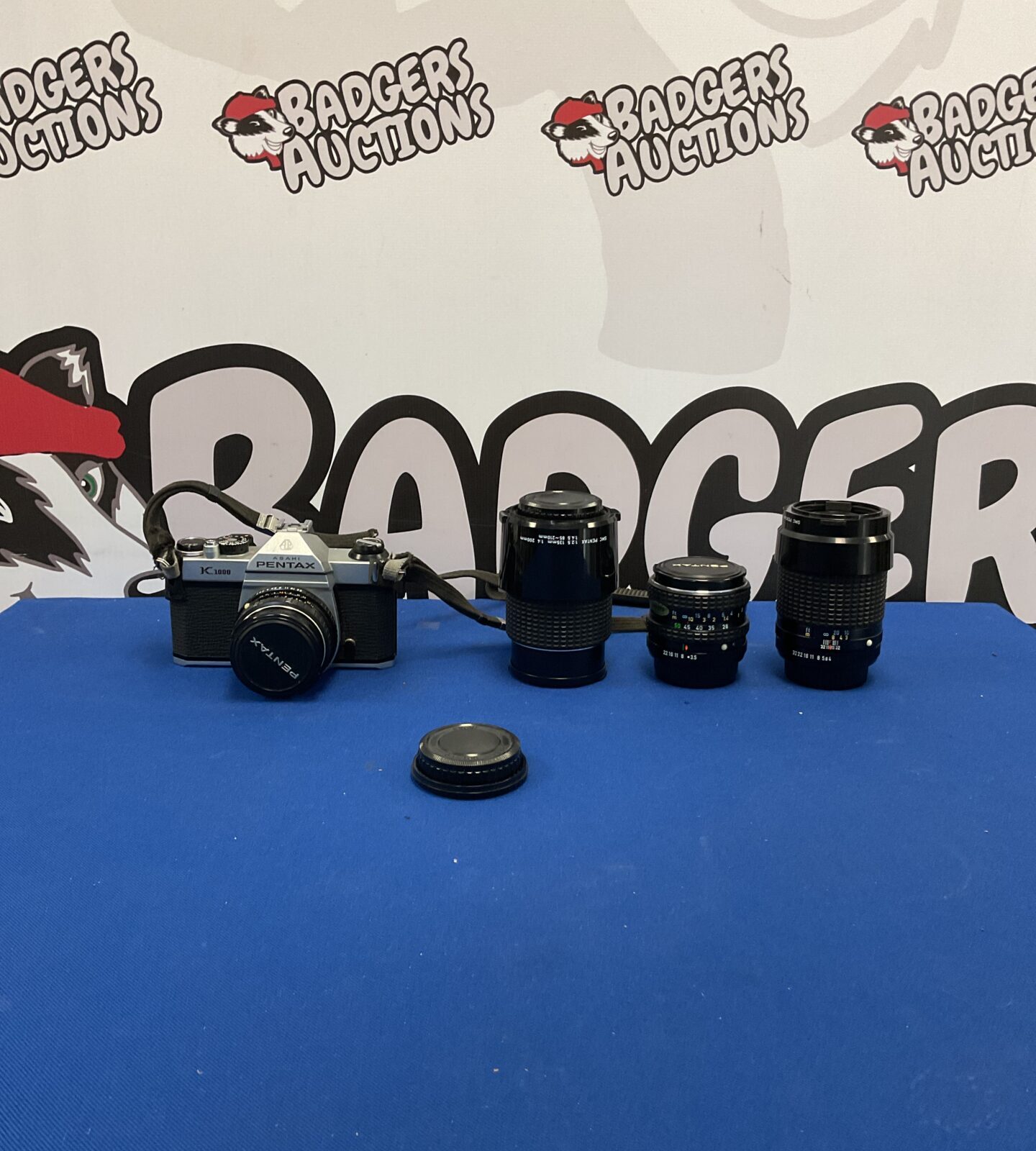 Vintage Pentax K1000 camera with three lenses for film photography.