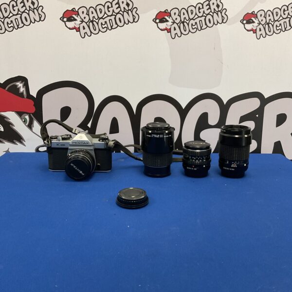Vintage Pentax K1000 camera with three lenses for film photography.