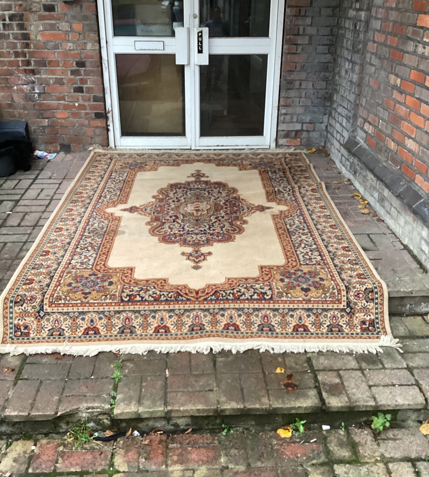 Vintage Persian rug with intricate floral patterns on a wooden floor.