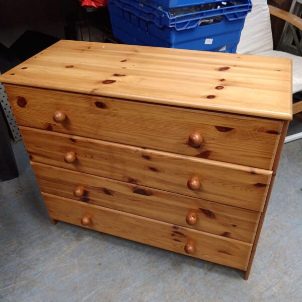 Front view of a vintage pine chest of drawers with four drawers.