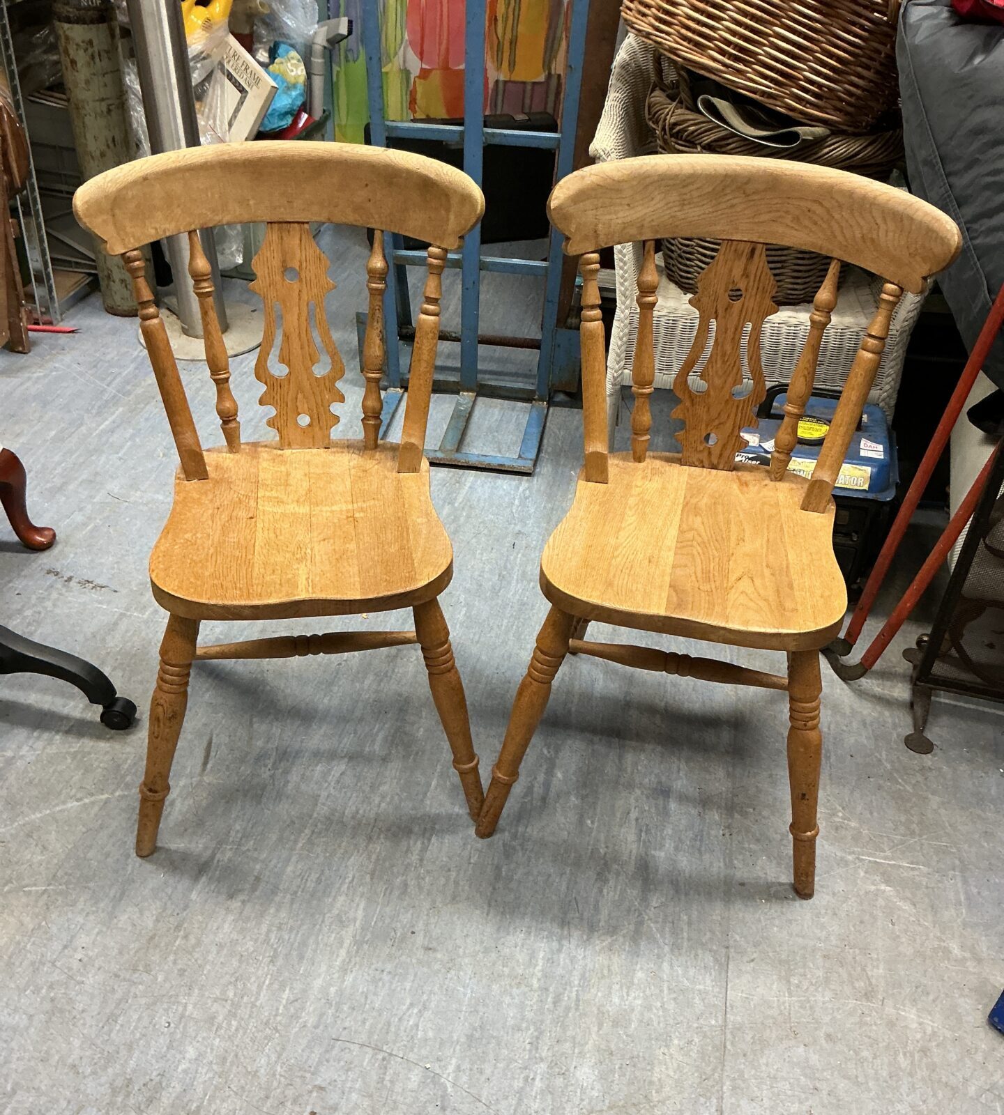 Pair of vintage pine kitchen chairs with rustic charm.