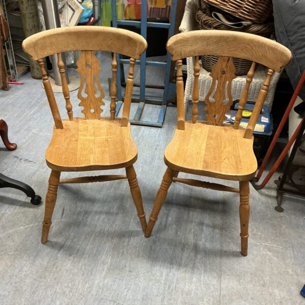Pair of vintage pine kitchen chairs with rustic charm.