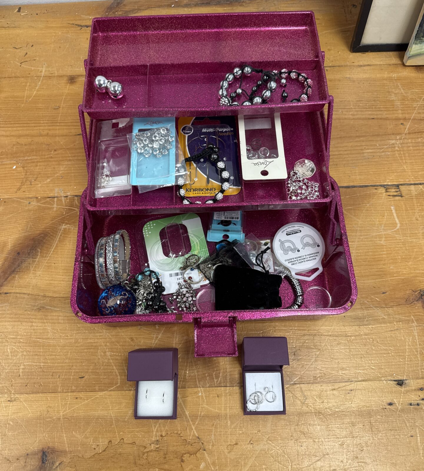 Vintage pink jewellery box filled with costume jewellery.