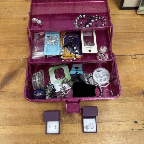 Vintage pink jewellery box filled with costume jewellery.