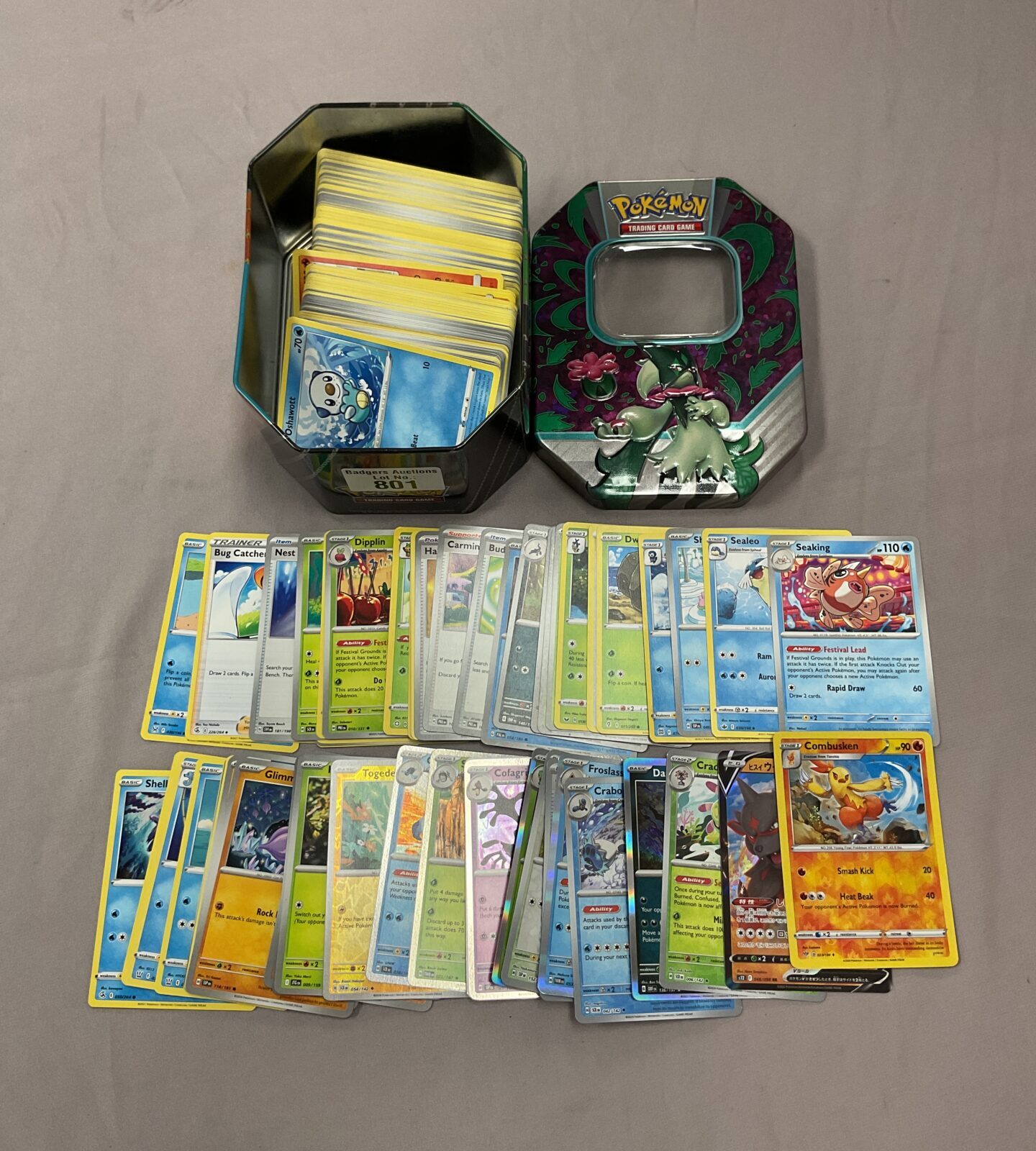 Pokemon card collection in a decorative tin with holo cards.