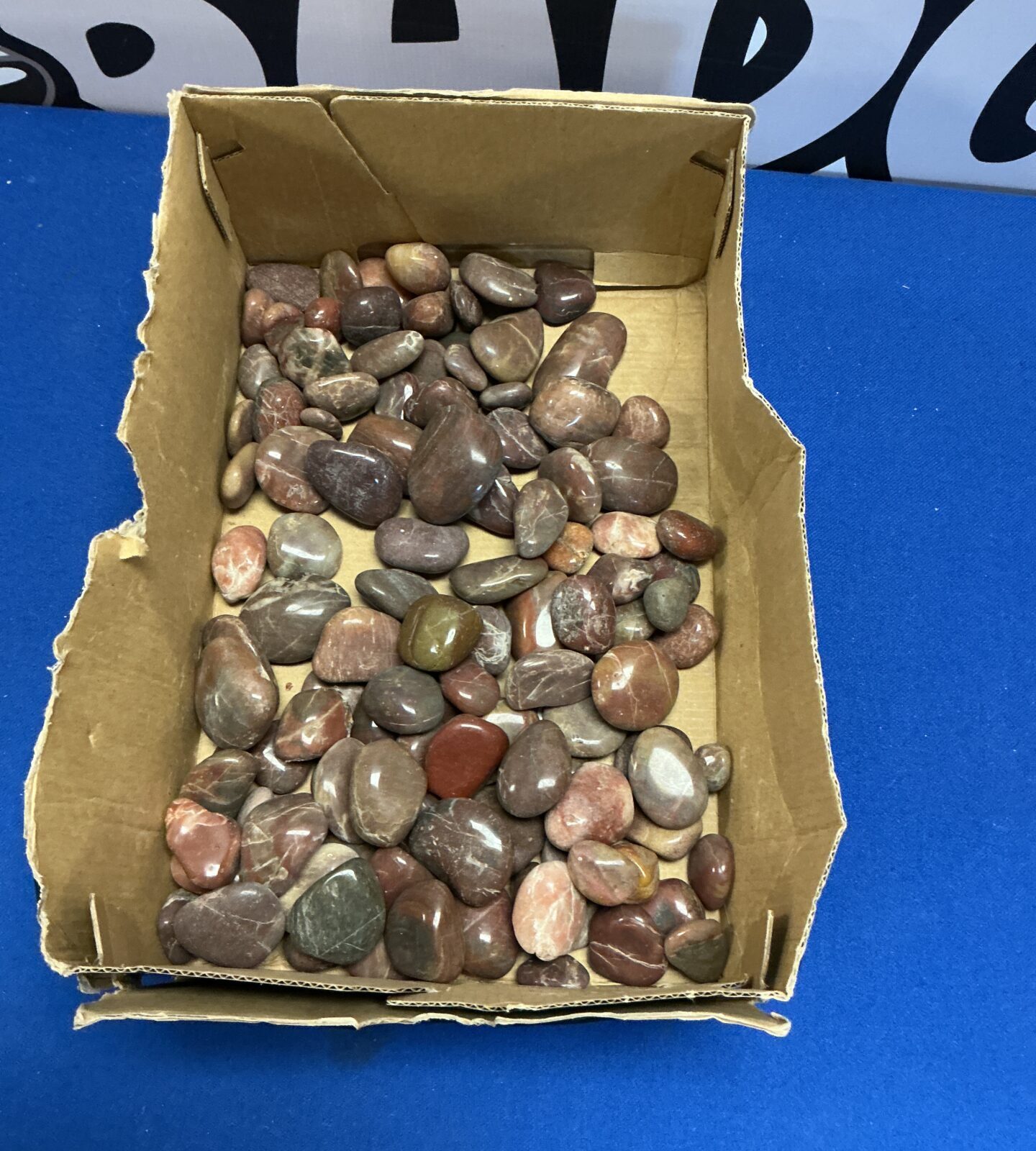 Tray of smooth, polished pebbles for crafts and decoration.