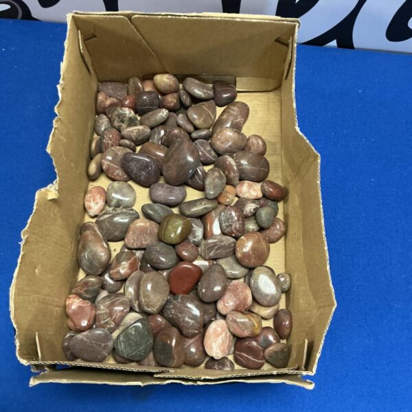 Tray of smooth, polished pebbles for crafts and decoration.