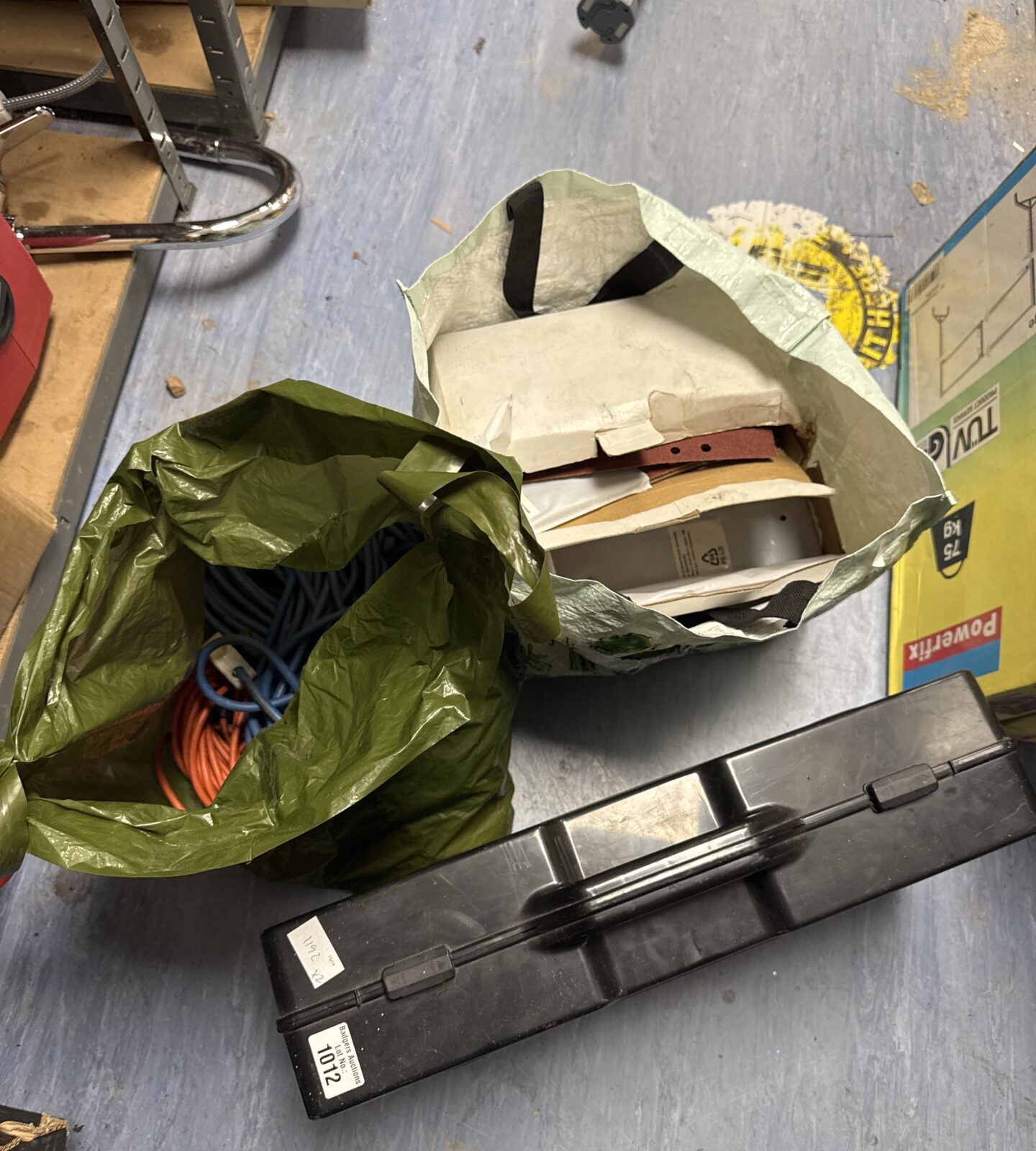 Open power tool set case with jigsaw, sander, and cables.