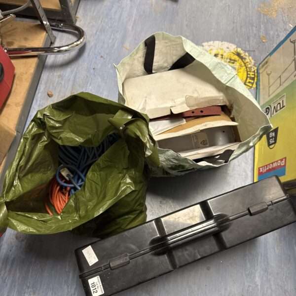 Open power tool set case with jigsaw, sander, and cables.