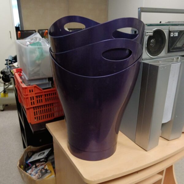Vibrant purple plastic waste paper bin for office or home use.