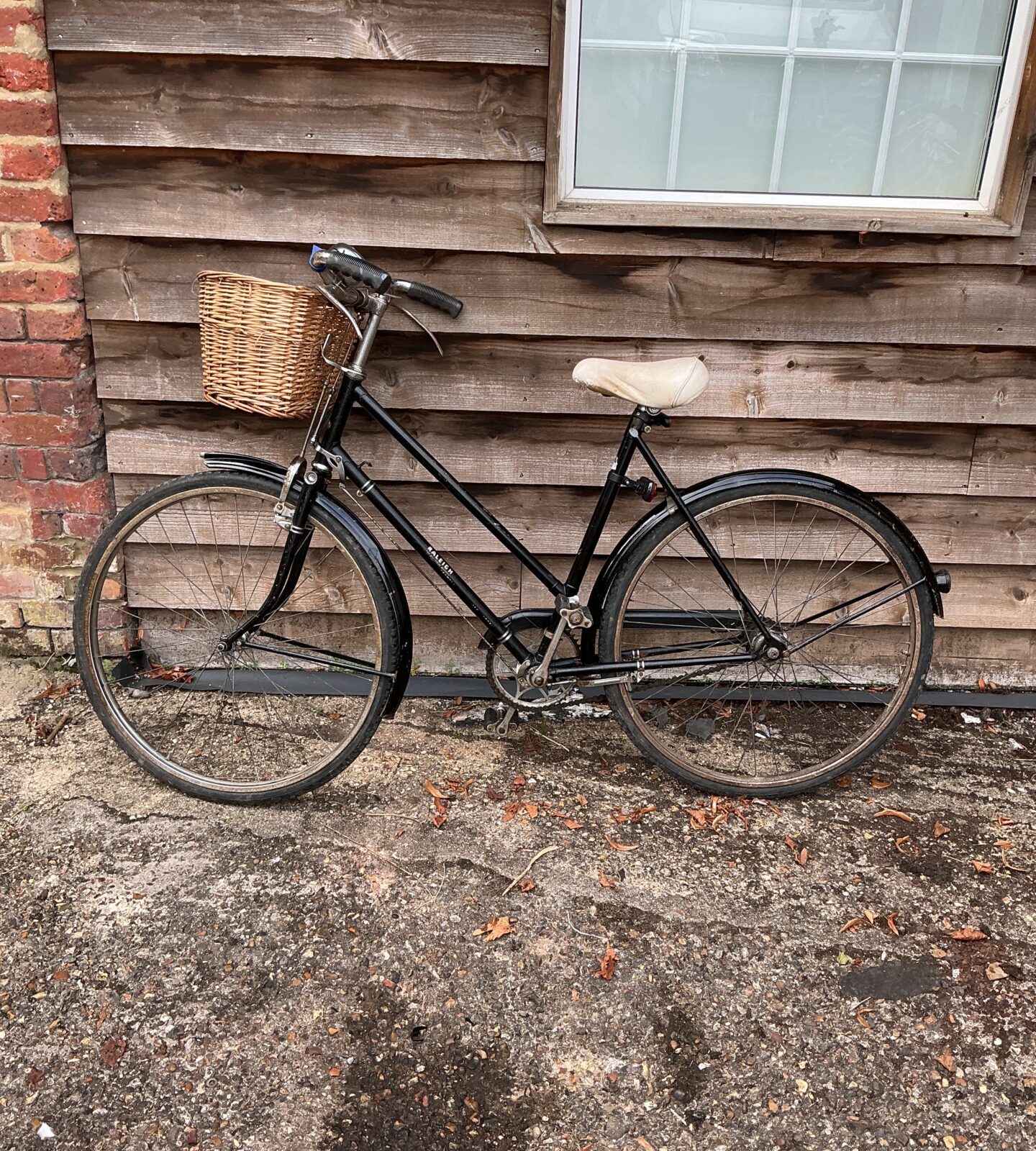 Classic Raleigh ladies bicycle with wicker basket, vintage style.