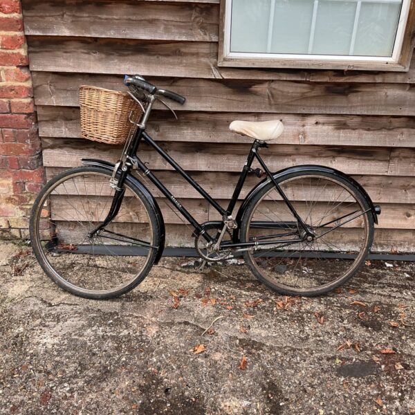 Classic Raleigh ladies bicycle with wicker basket, vintage style.