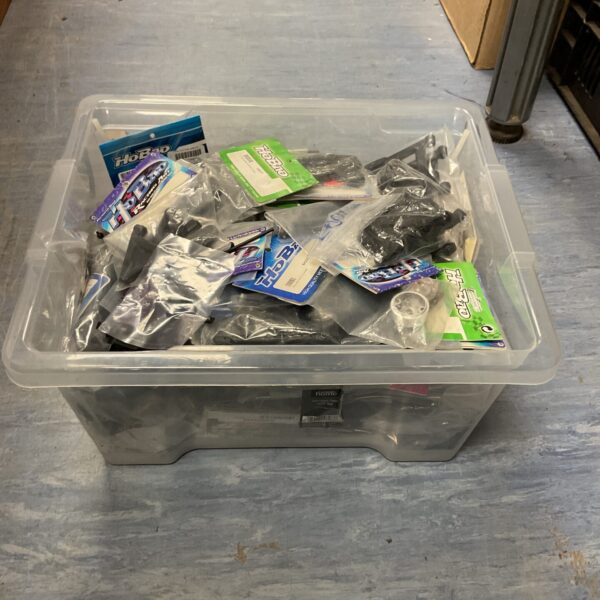 Mixed lot of RC model parts and accessories in a storage box.