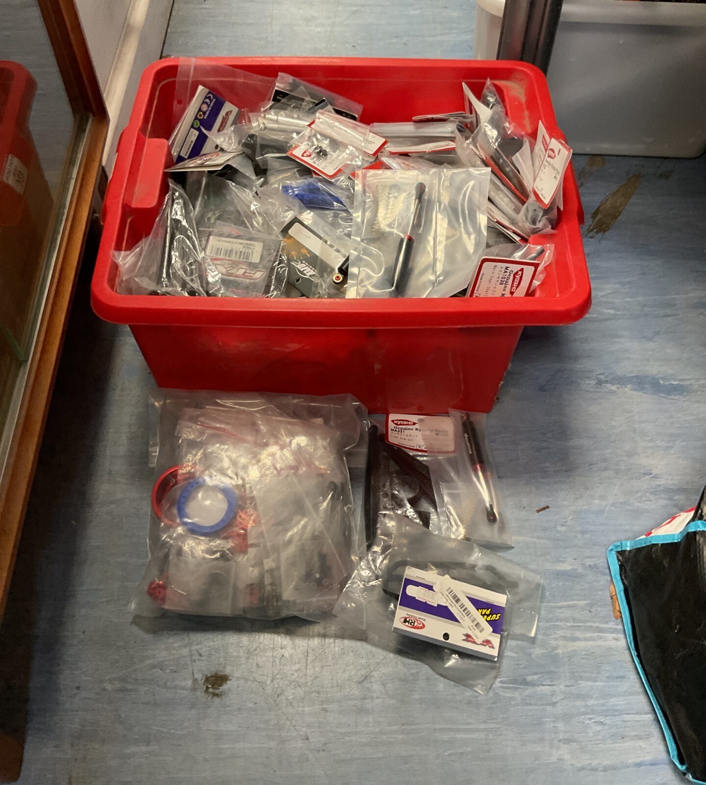 Assorted RC model parts in a plastic storage bin.
