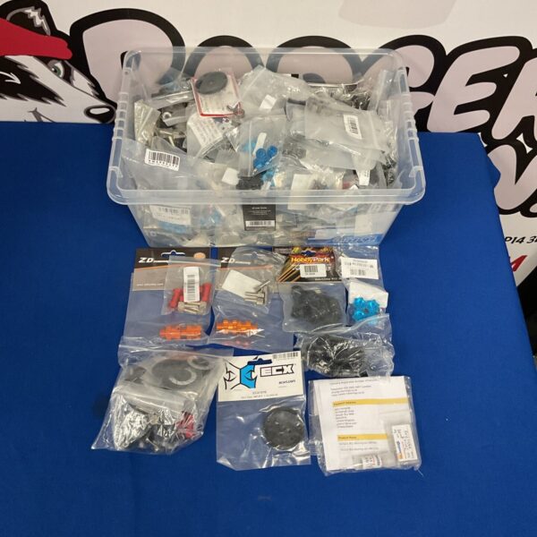 Assorted RC model parts and hobby accessories in a plastic storage box.