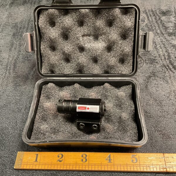 Close-up of a compact red dot gun sight for firearms.