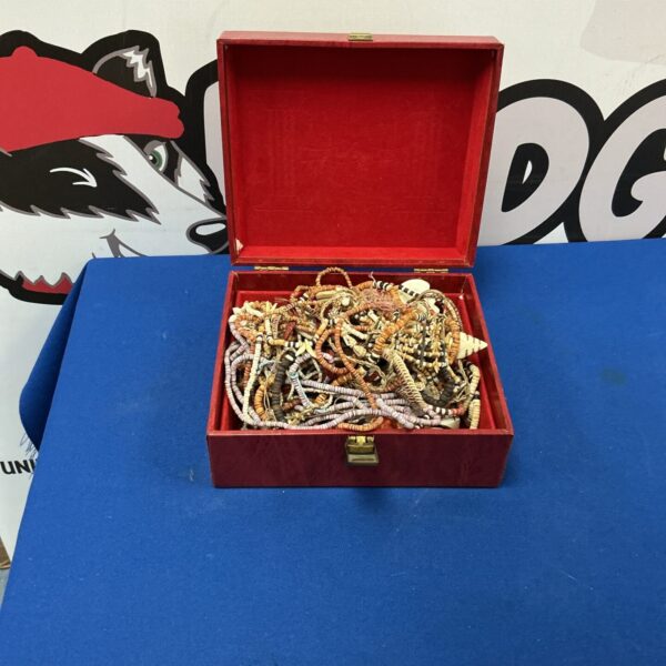 Open red leather jewellery box filled with colourful beaded necklaces.