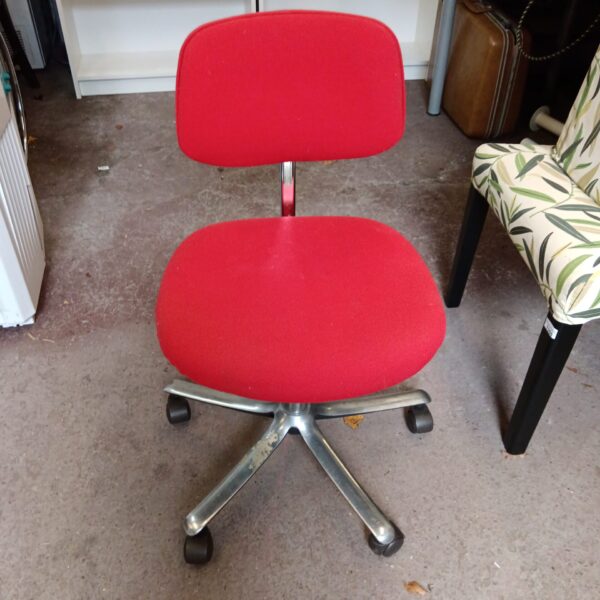 Vintage red office chair with metal base and casters.
