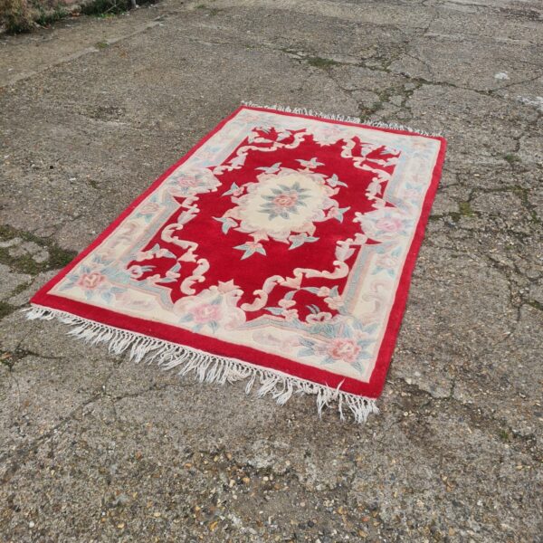 Detailed view of a red oriental rug with floral patterns.