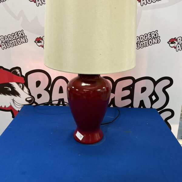 Vintage red pottery table lamp with a classic design.