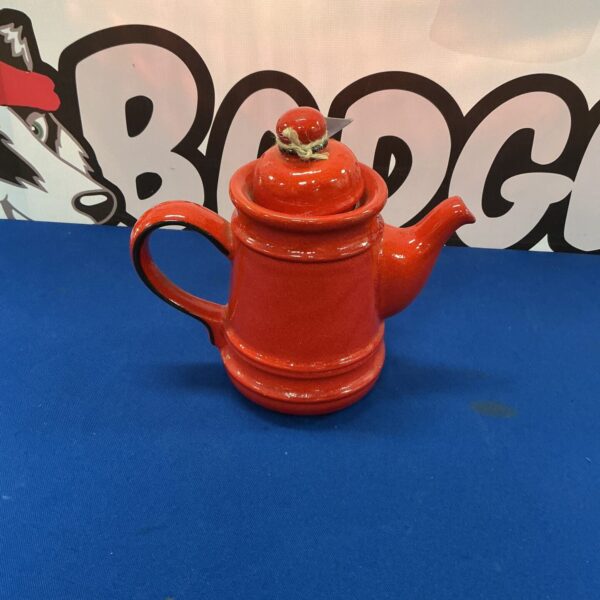 Vibrant red pottery teapot for farmhouse kitchen decor.