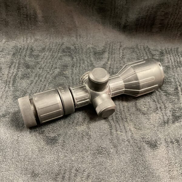 Illuminated rifle scope with rubber armor for hunting and tactical use.