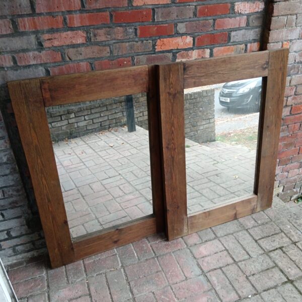 Large rustic pine framed mirror reflecting a room.