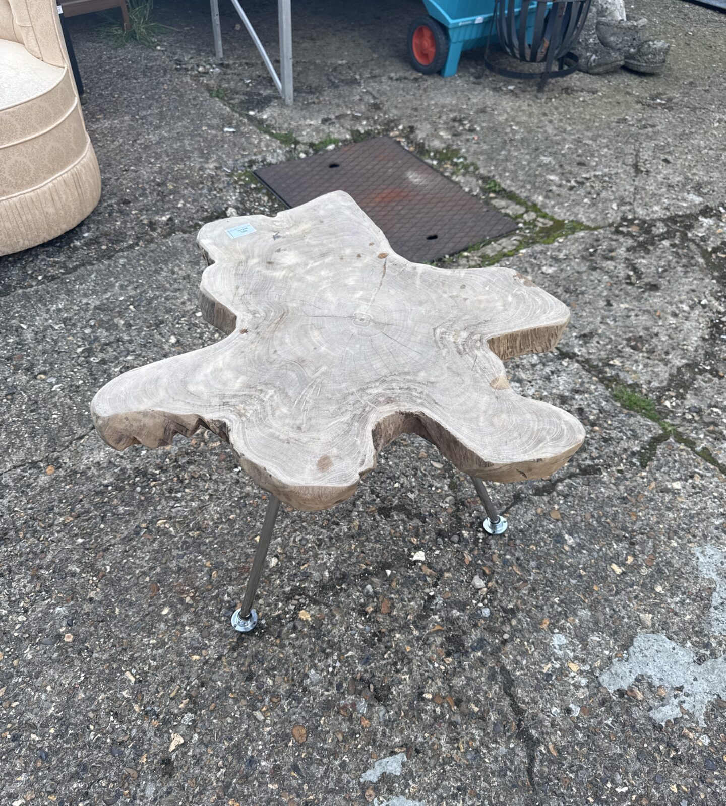 Rustic wood side table with starburst top and metal legs.