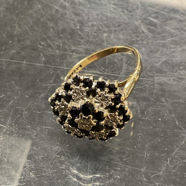 Close-up of a 9ct gold sapphire and diamond cluster ring.