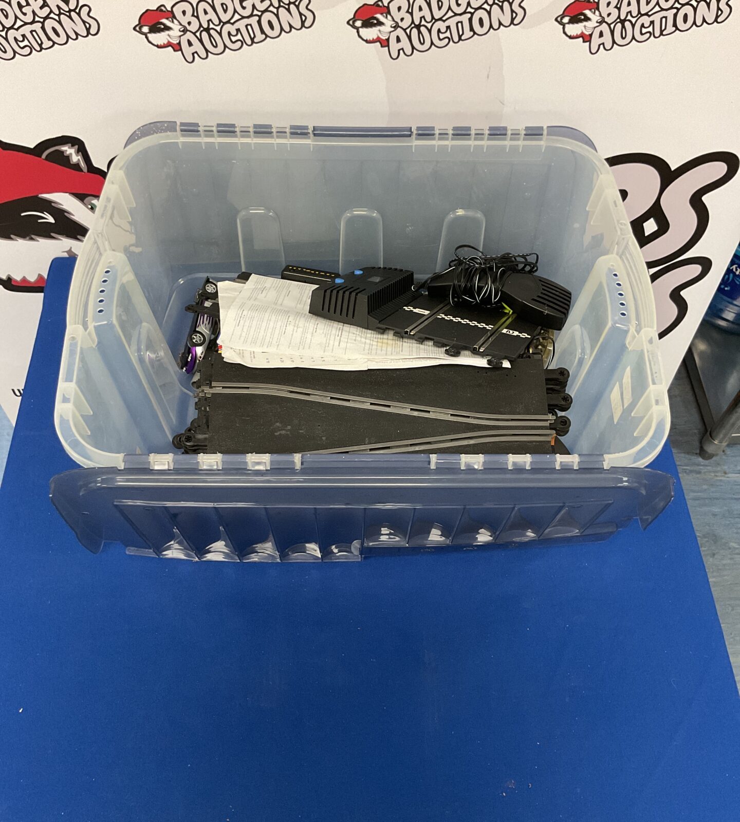 Scalextric track set with cars in a storage box.