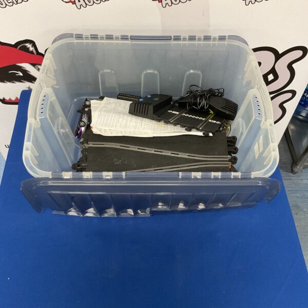 Scalextric track set with cars in a storage box.