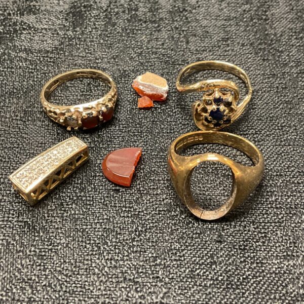 Close-up of a scrap gold lot featuring ring fragments.