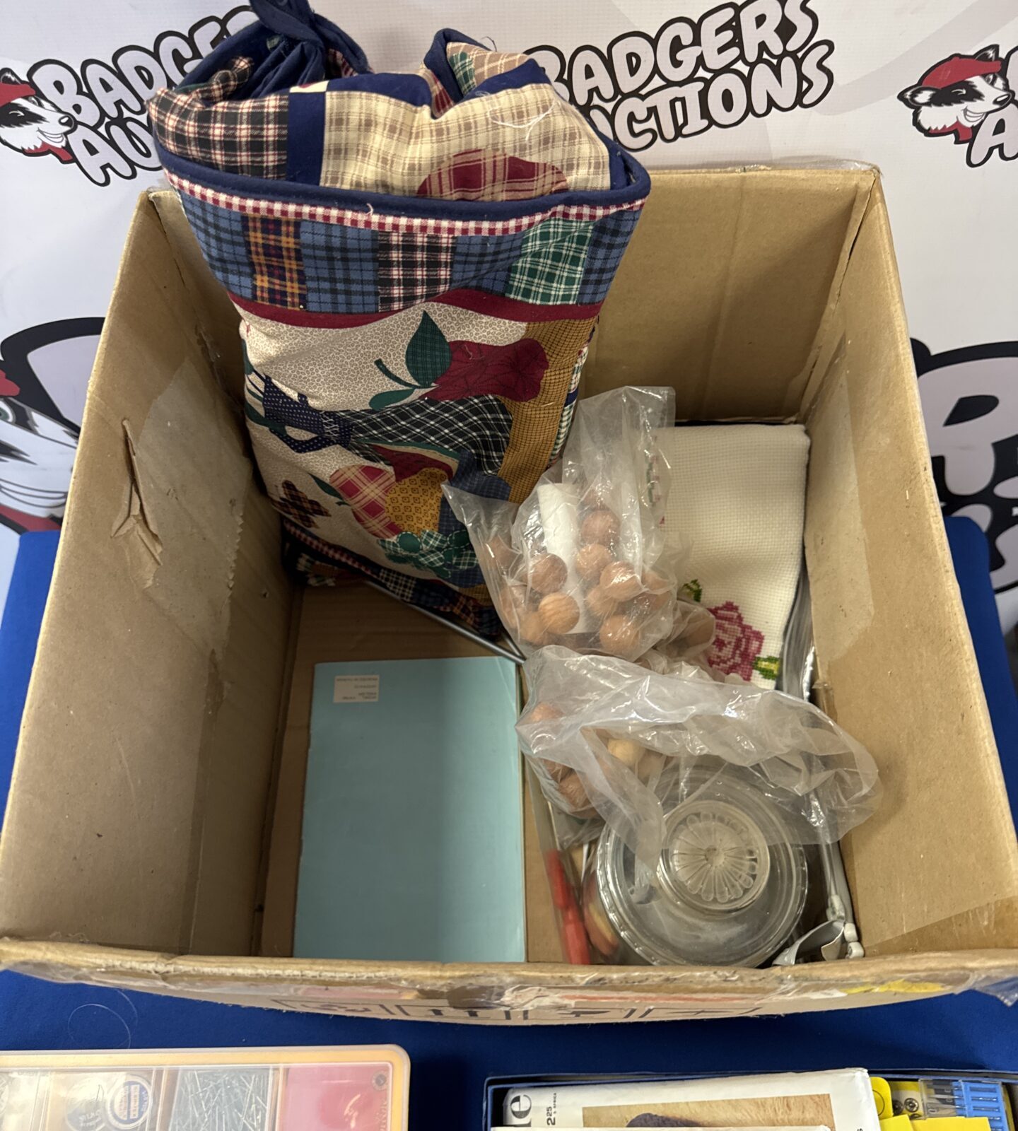 Assorted sewing and embroidery supplies on a blue surface.