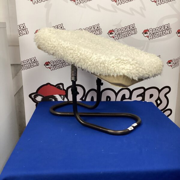 Creamy white sheepskin foot stool for rustic home decor.