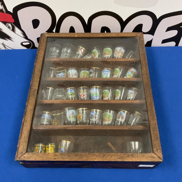 Wooden shot glass display case with miniature glass collection.