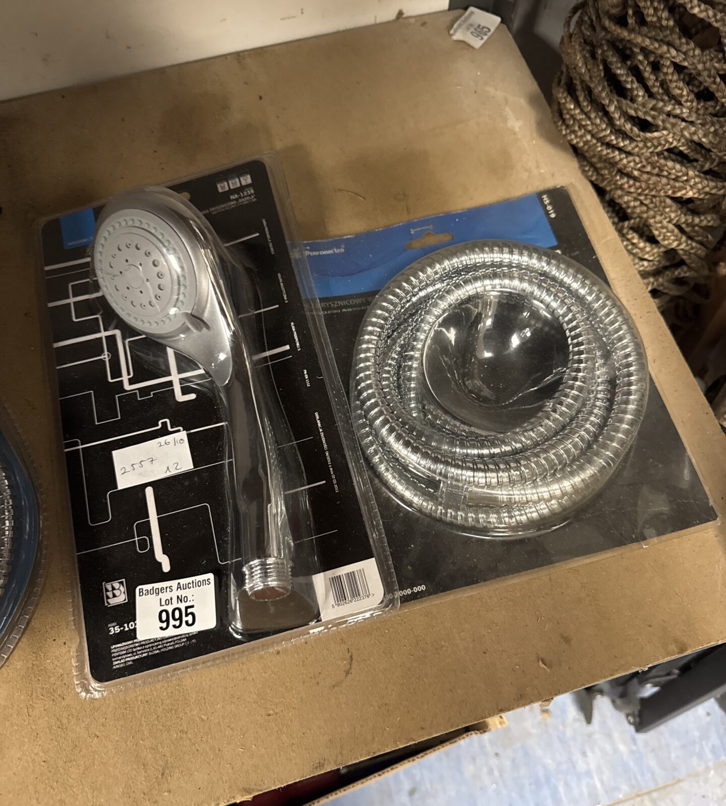 New chrome shower head and hose set in original packaging.