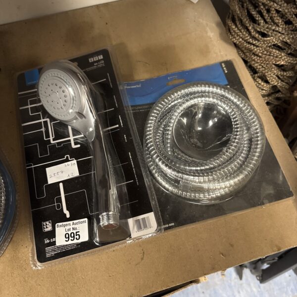 New chrome shower head and hose set in original packaging.