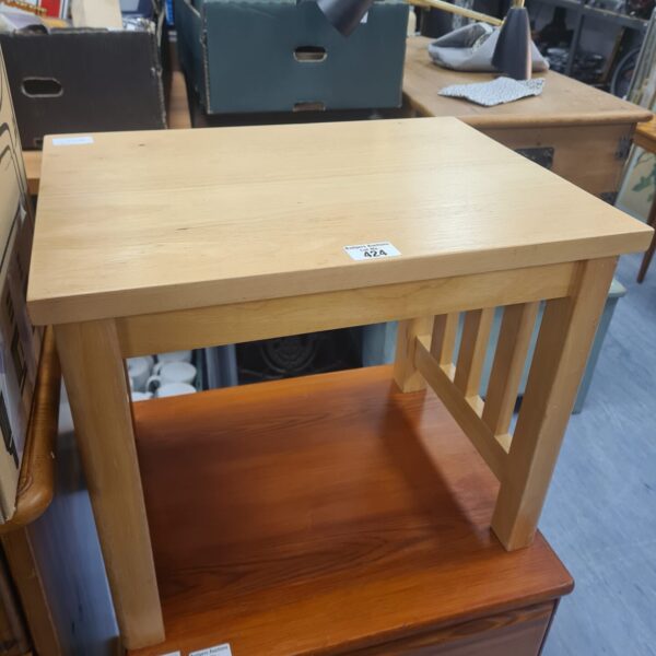 Small beach style side table with light wood finish.