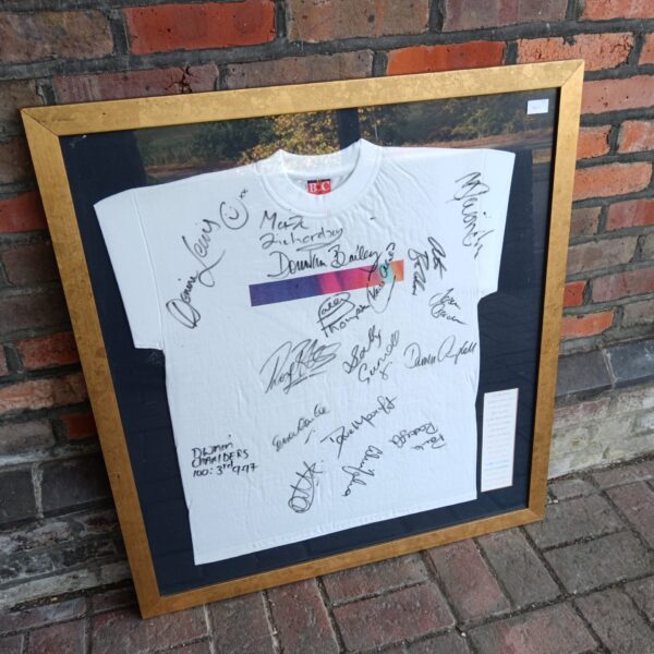 Framed signed sports t-shirt with athlete autographs, including Denise Richards.