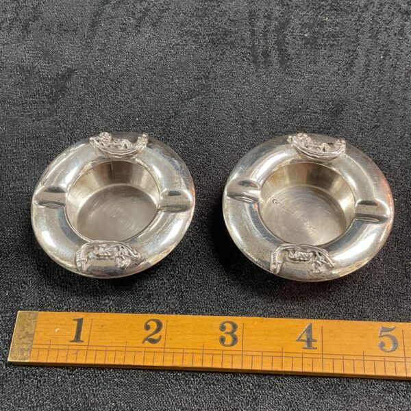 Pair of vintage 925 silver ashtrays on a white surface.