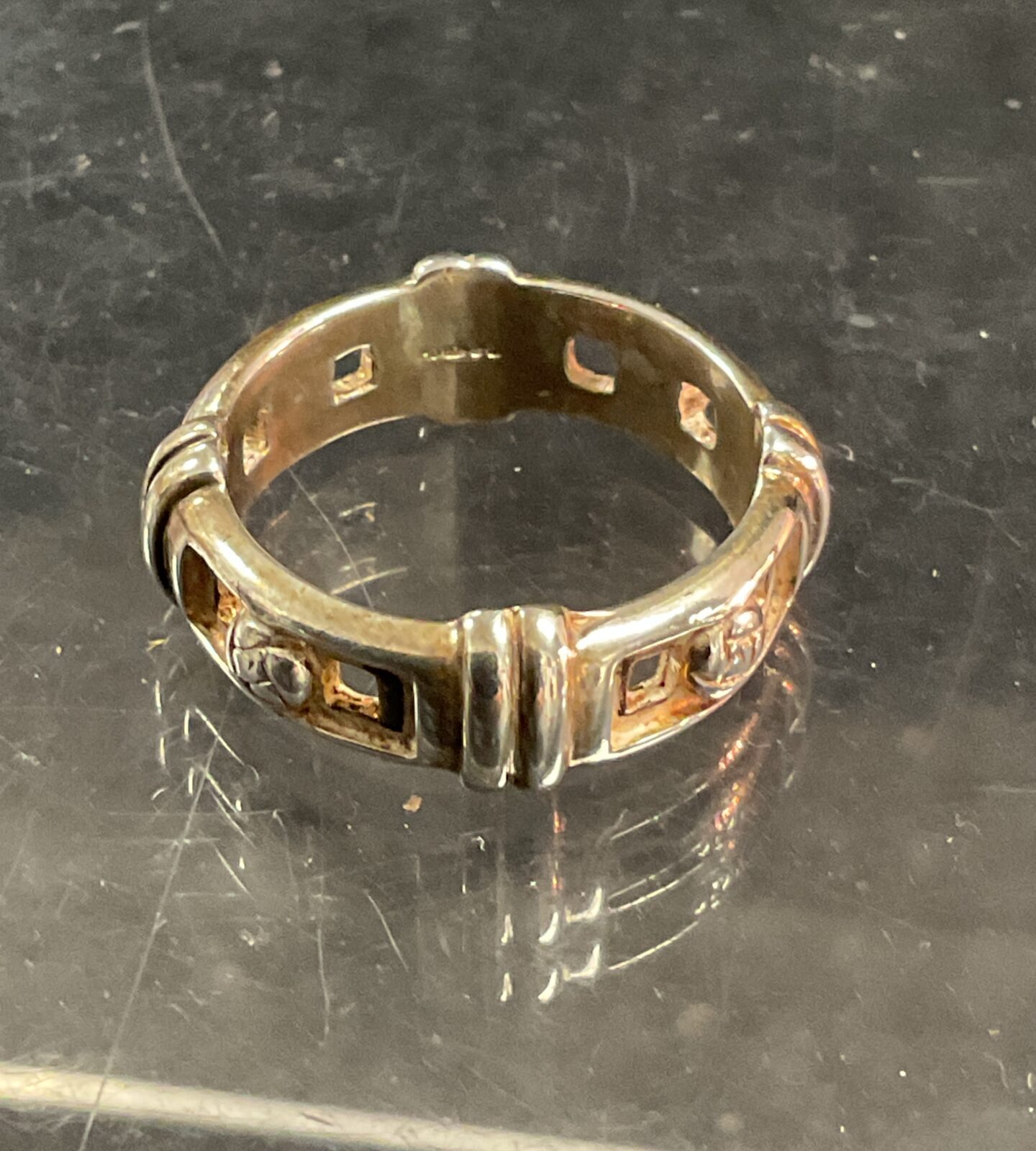 Detailed silver belt buckle ring with embossed design.