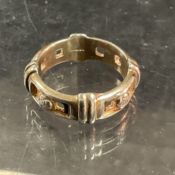 Detailed silver belt buckle ring with embossed design.