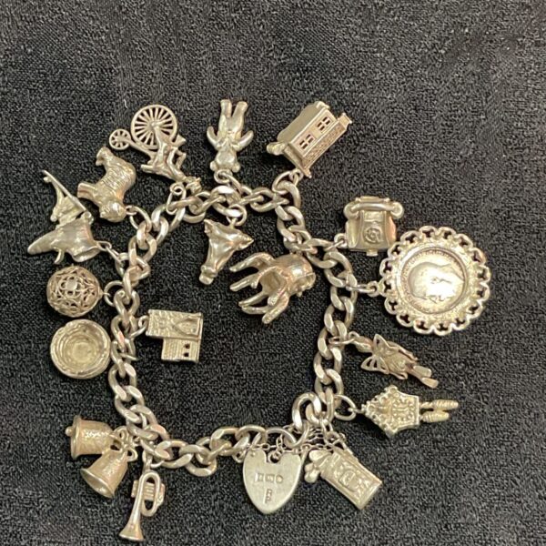 Vintage silver charm bracelet with seventeen detailed charms.