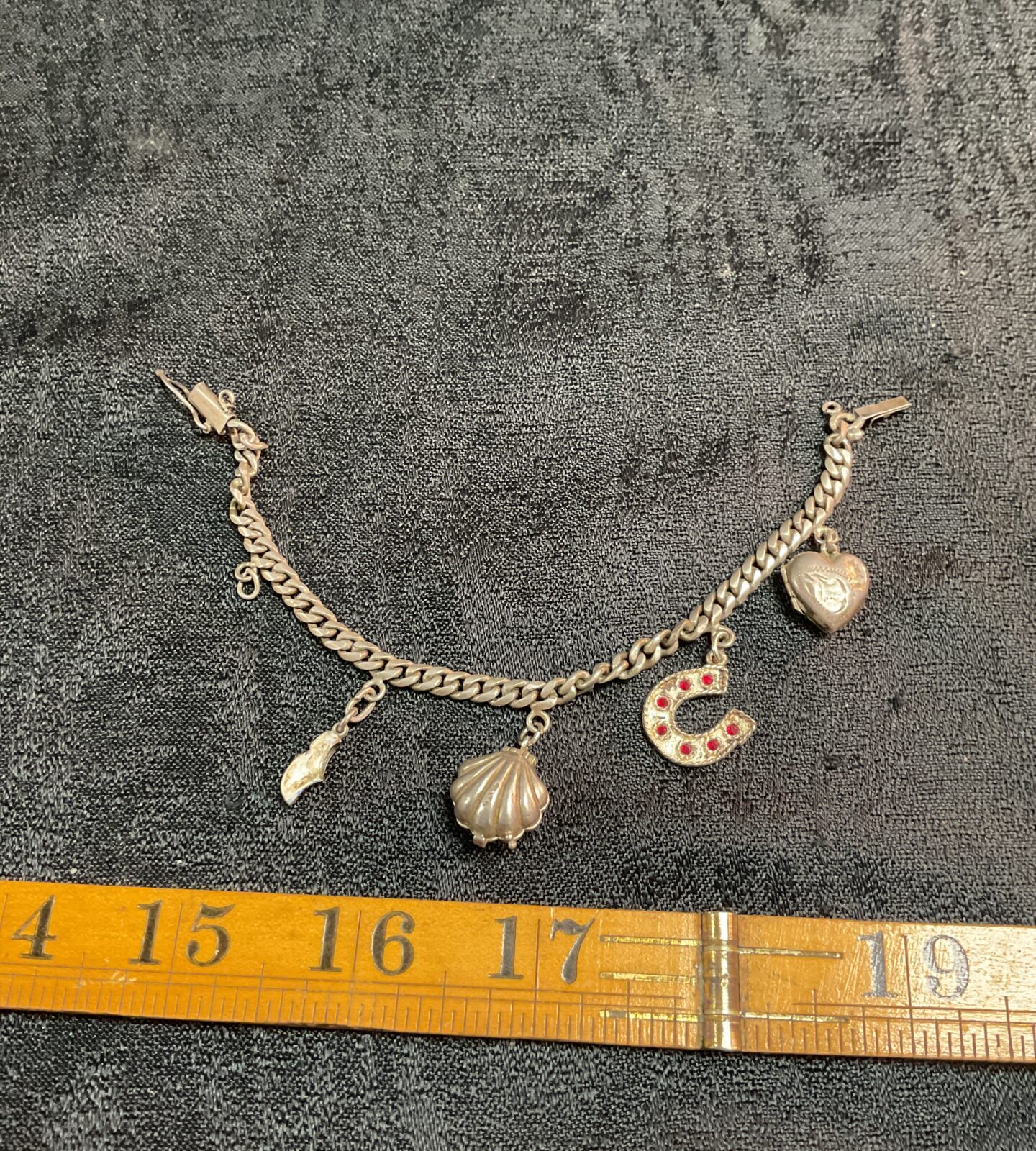 Vintage silver charm bracelet with five unique charms.